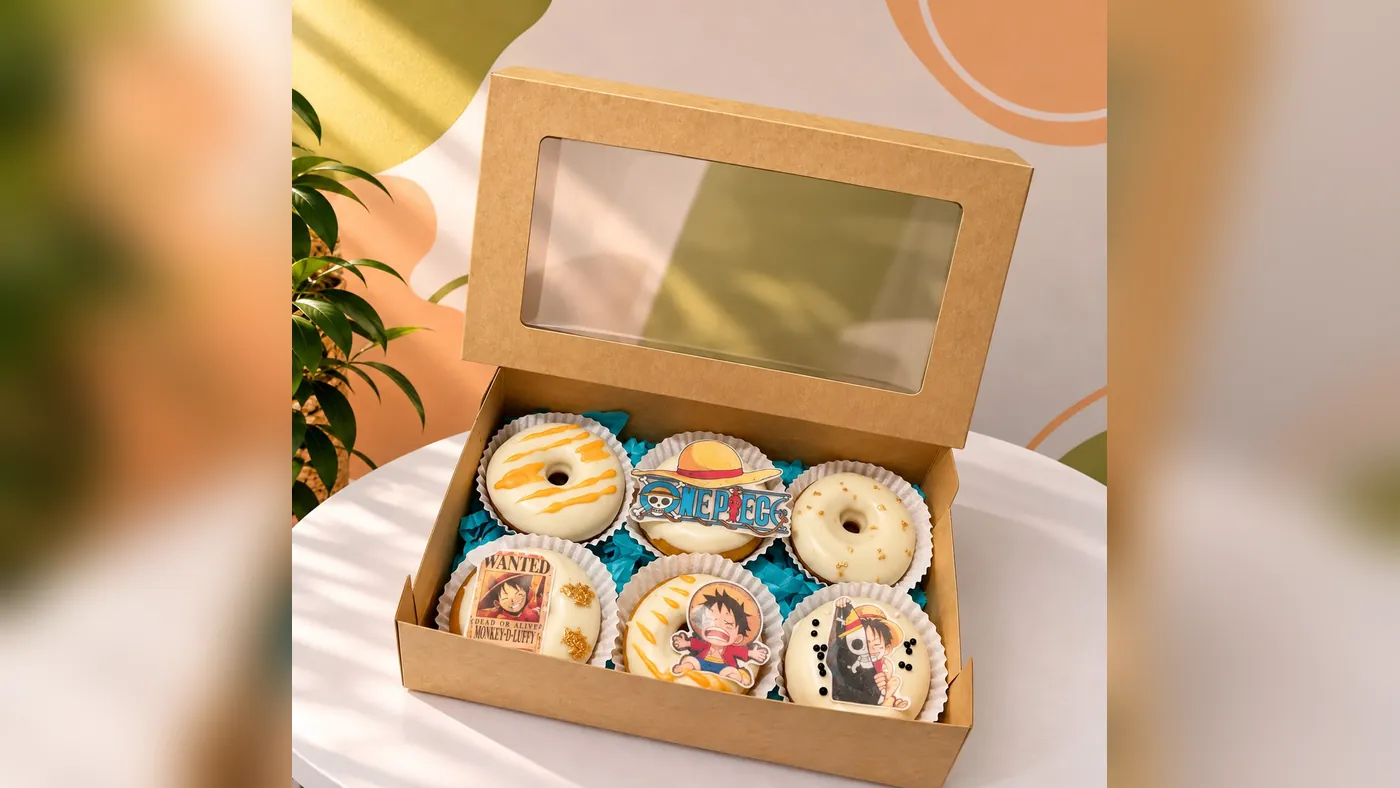 Caja kraft con ventana y seis donas bañadas en chocolate blanco, decoradas con imágenes de One Piece, Detalles de Amor Medellín