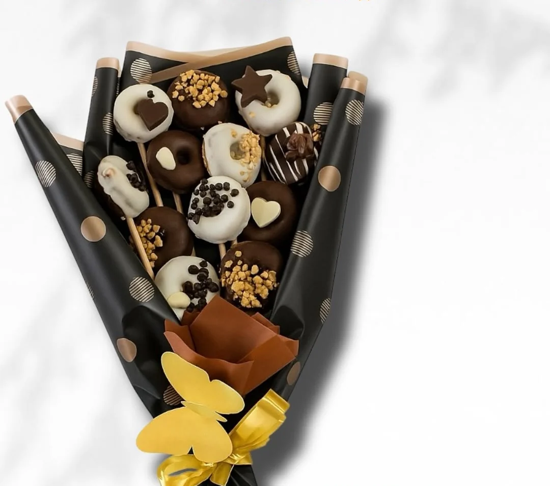 Ramo de mini donas bañadas en chocolate, envuelto en papel negro con puntos dorados, Detalles de Amor Medellín