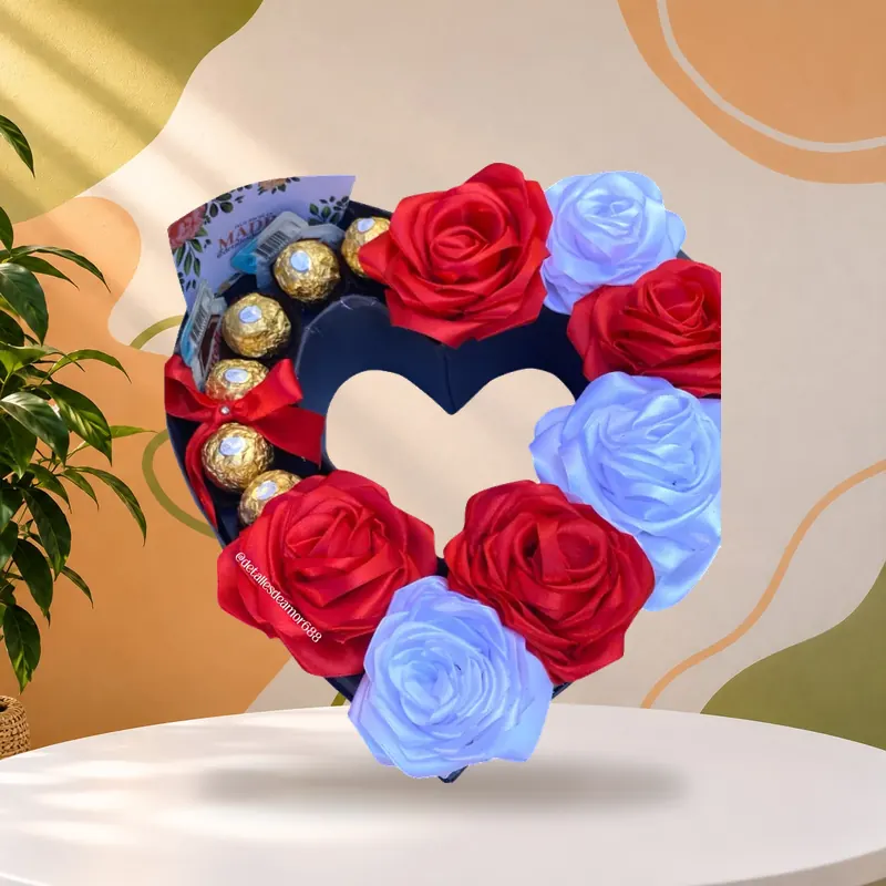 Rosas eternas artesanales en cinta de satín roja y blanca en una caja de corazón